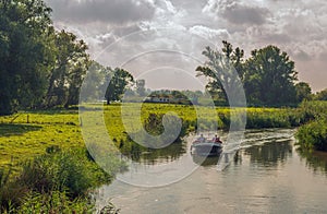 Two unrecognizable people sail through a stream with a sloop photo