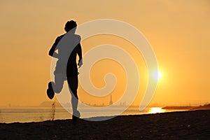 Backlight of a man running on the beach at sunset