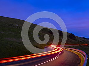 Backlights, car driving at speed at night on road photo