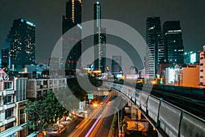 Backlights of moving cars with the skyline of Bangkok in the background