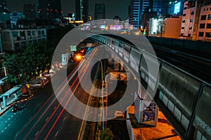 Backlights of moving cars and skytrain station in Bangkok, Thailand