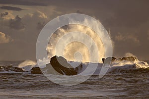 Backlit big wave splash at sunset