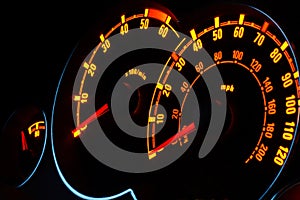 Backlit car dashboard dials glowing at night photo