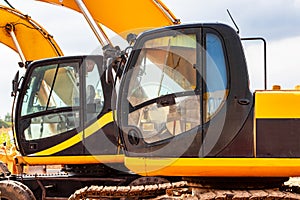 Backlit excavator on an industrial site against the background of the evening sky. Construction machinery for earthworks