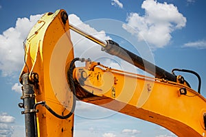 Backlit excavator on an industrial site against the background of the evening sky. Construction machinery for earthworks