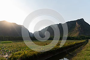 Backlit Mountains of Ninh Binh with water filled rice fields in the forground at sunset