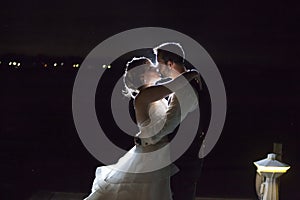 Backlit night wedding couple kissing