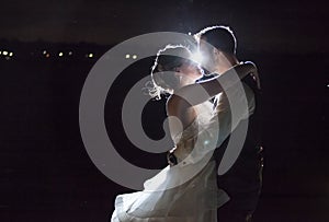 Backlit night wedding couple kissing