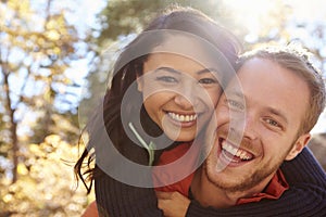 Backlit portrait of mixed race couple embracing in a forest