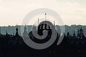 Backlit Prague skyline buildings siwh smoke chimneys silhouette