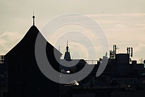 Backlit Prague skyline buildings siwh smoke chimneys silhouette