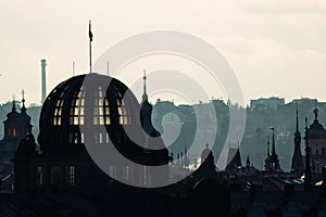 Backlit Prague skyline buildings siwh smoke chimneys silhouette