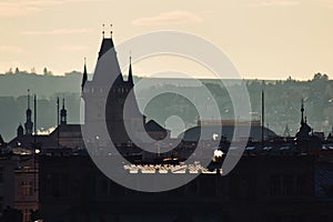 Backlit Prague skyline buildings siwh smoke chimneys silhouette