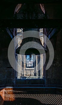 Backlit silhouettes of two restored bronze bells from the tower of the Clerecia church with the view of the city of Salamanca from