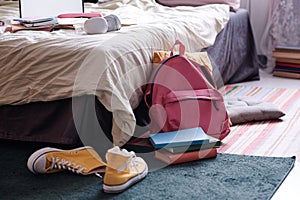 Backpack And Book In Teenagers Room