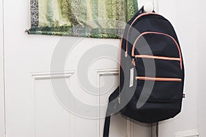 A backpack hanging on a door. Ready to go back to school