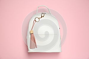 Backpack with leather keychain on pink background, top view