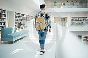 Backpack, library and education with a man student walking in a university bookstore for learning or development. Back