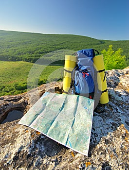 Backpack and map in mountain.