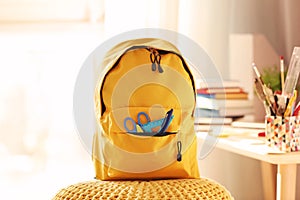 Backpack with school supplies on pouf photo