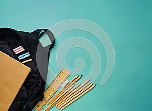 Backpack with stationery on blue background