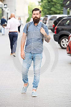 Backpack for urban travelling. Hipster wearing backpack urban street background. Bearded man travel with backpack. Guy