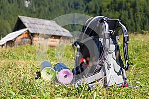 Backpack and yoga mats on mountain meadow.