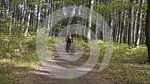 Backpacked man rides bicycle in the forest