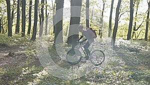 Backpacked man rides bicycle in the forest