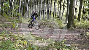 Backpacked man rides bicycle in the forest