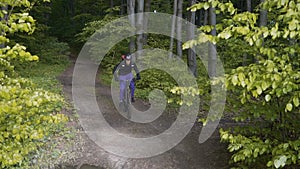 Backpacked man rides bicycle in the forest