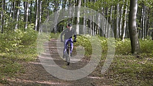 Backpacked Man Rides Bicycle in the Forest