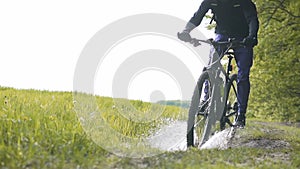 Backpacked Man Rides Bicycle in the Forest Puddle Pool