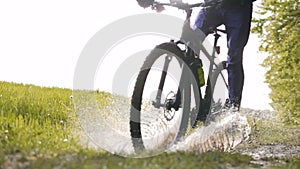 Backpacked Man Rides Bicycle in the Forest Puddle Pool