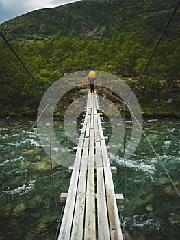 A backpacker on the end of a rope bridge