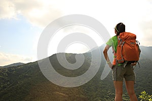 Backpacker enjoy the view at mountain peak cliff