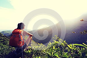 Backpacker enjoy the view at mountain peak cliff