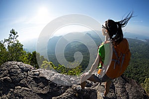 Backpacker enjoy the view on mountain top cliff edge