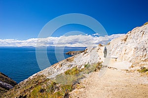 Backpacker exploring the majestic Inca Trails on Island of the Sun, Titicaca Lake, among the most scenic travel destination in Bol