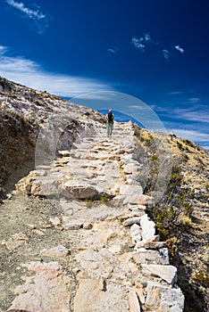 Backpacker exploring the majestic Inca Trails on Island of the Sun, Titicaca Lake, among the most scenic travel destination in Bol