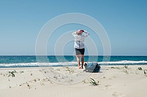 Backpacker female on the Patara sand dunes beach enjoying the windy Mediterranean Sea during Lycian Way trekking walk. Famous