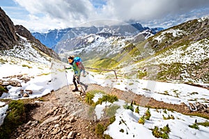 Backpacker female tourist hiking alone mountain footpath South Tyrol, Italy