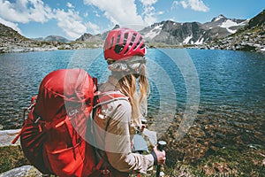 Backpacker girl hiking at blue lake in mountains with red backpack Travel Lifestyle adventure