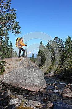 Backpacker girl on a rock looking route map