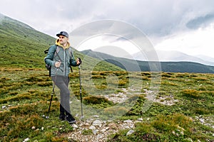 Backpacker guy engaged nordic walking outdoors