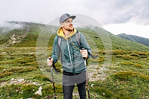 Backpacker guy engaged nordic walking outdoors