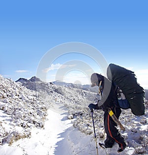 Backpacker with heavy pack walk on the snow