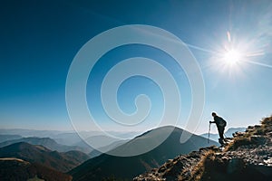 Backpacker hiker on the mountain hill in contrast sun light