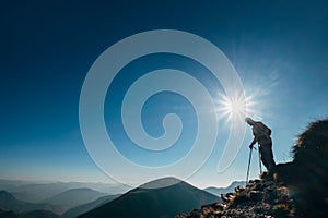 Backpacker hiker on the mountain hill in contrast sunlight going