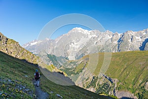 Backpacker hiking on the Alps, majestic Mont Blanc in background